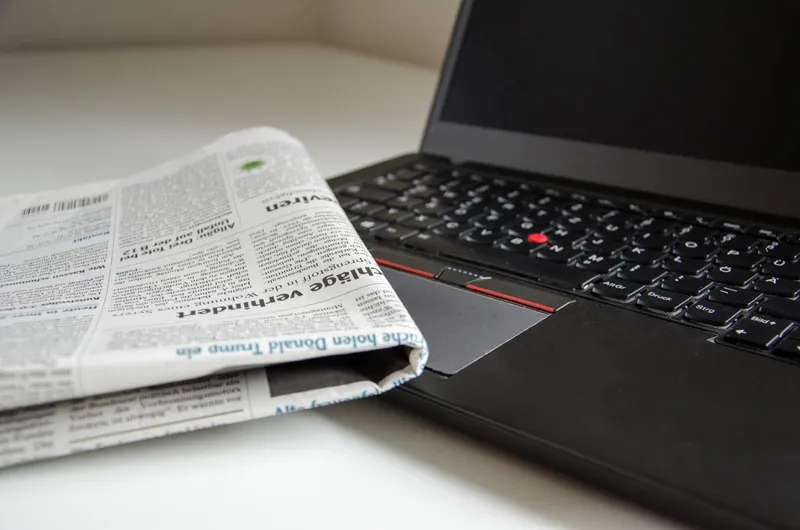 An image of a newspaper and a computer